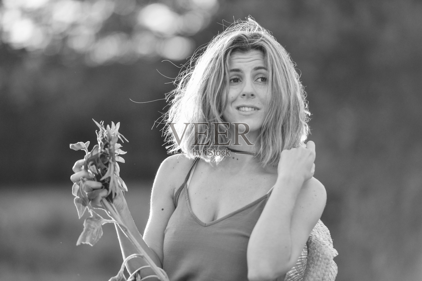 一个黑发女孩的肖像,手里拿着向日葵照片摄影图片