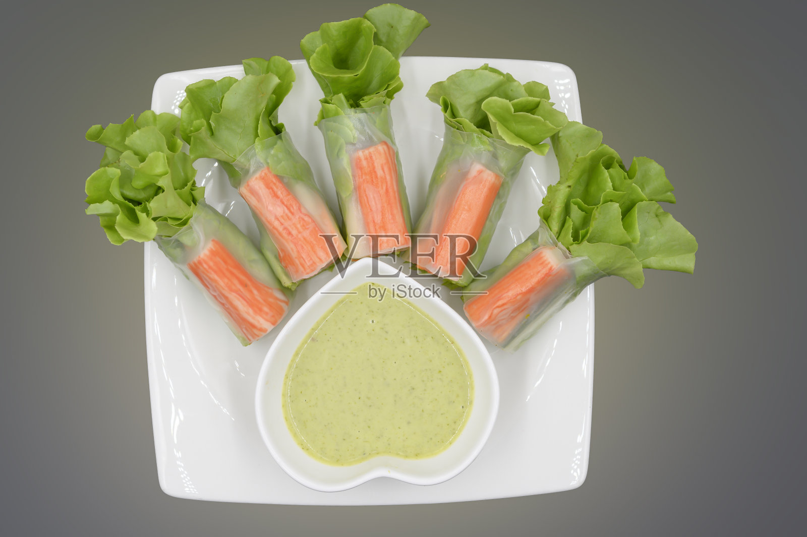 蔬菜沙拉配蟹肉条,配酱汁,放在白盘子里照片摄影图片