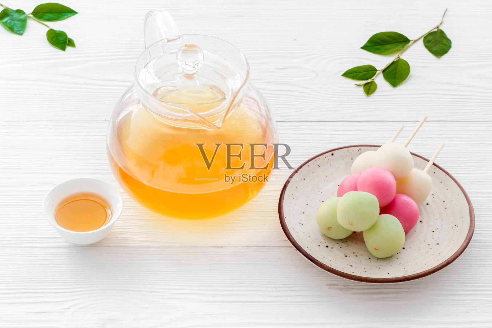 以甜食和茶为背景的日本食物。三种颜色的饺子照片摄影图片