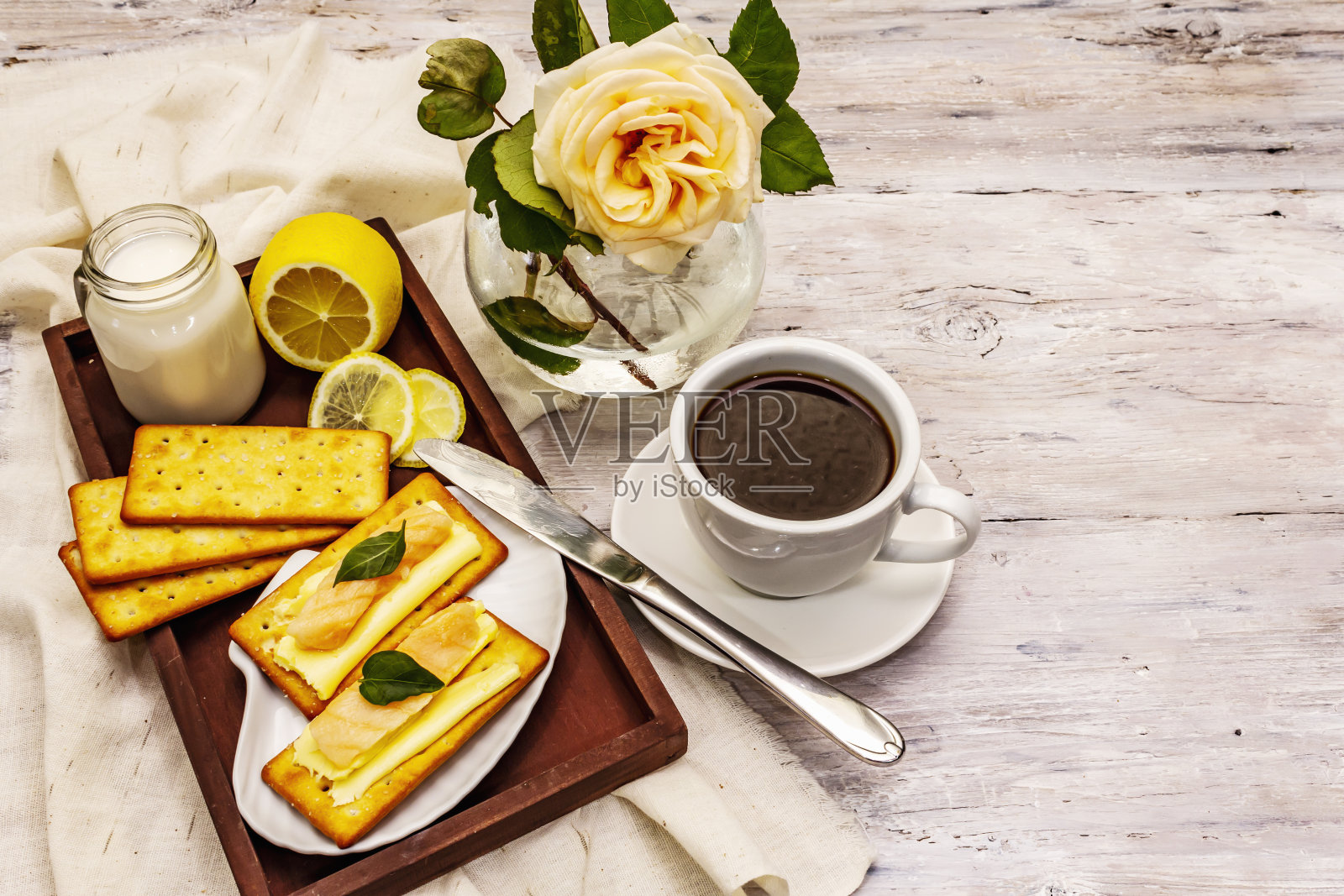 健康的早餐。一杯咖啡(红茶),牛奶,黄油饼干和鲑鱼。早上好心情照片摄影图片