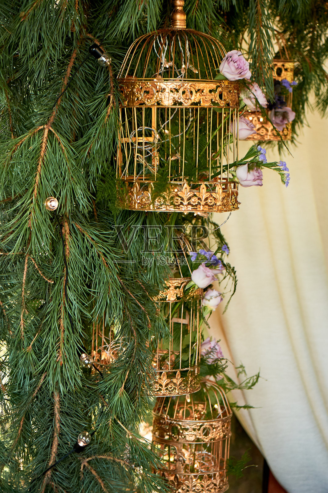 婚礼花艺。Eco的风格。树枝上挂着金笼子和花。拱的分支照片摄影图片