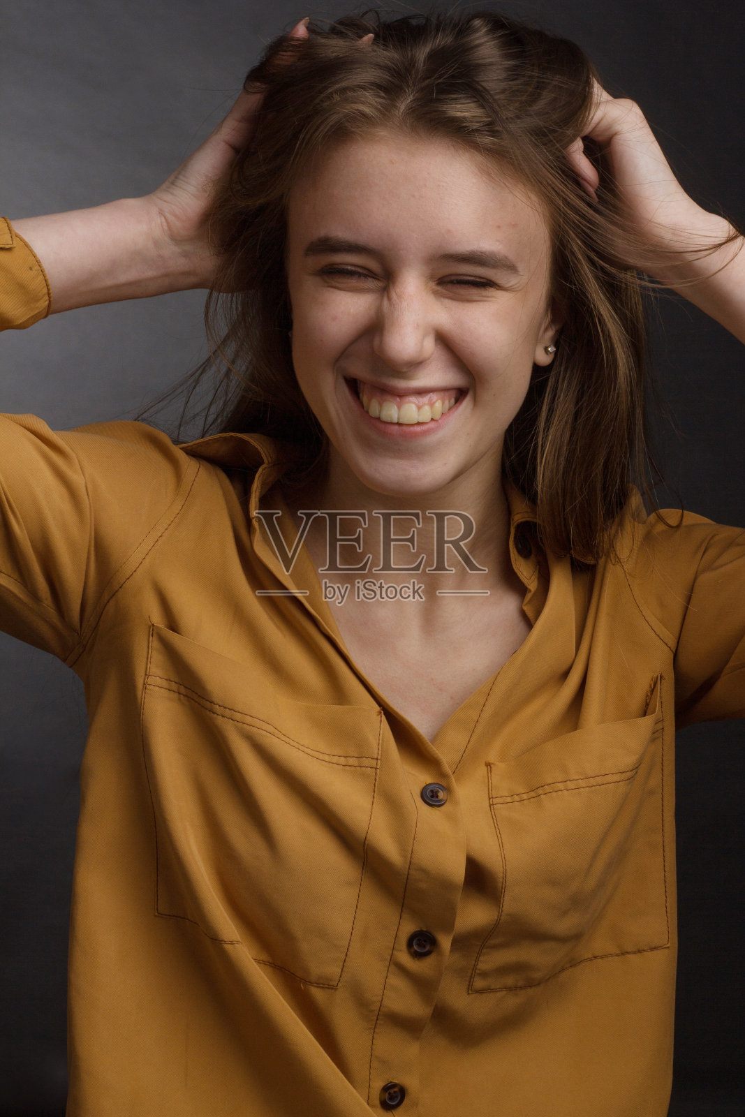 一个在黑色背景上长头发的年轻女孩的工作室肖像。照片摄影图片