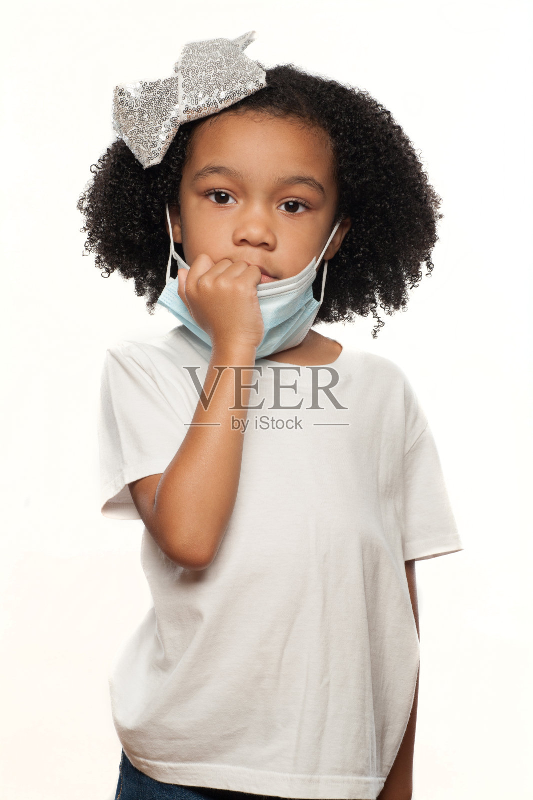 可爱的年轻富有表现力的非洲裔美国女孩戴着外科手术口罩在一个白色的背景照片摄影图片