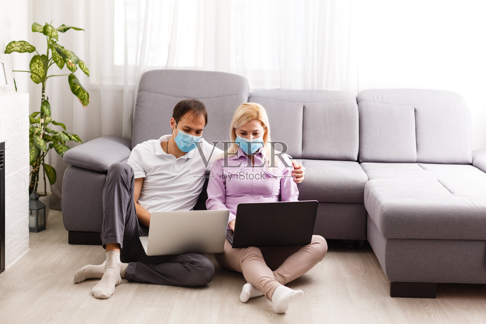 一个年轻的家庭使用电脑在家工作。夫妇在隔离期间远程在线工作。呆在家里的概念。冠状病毒covid-19大流行爆发。自由职业照片摄影图片