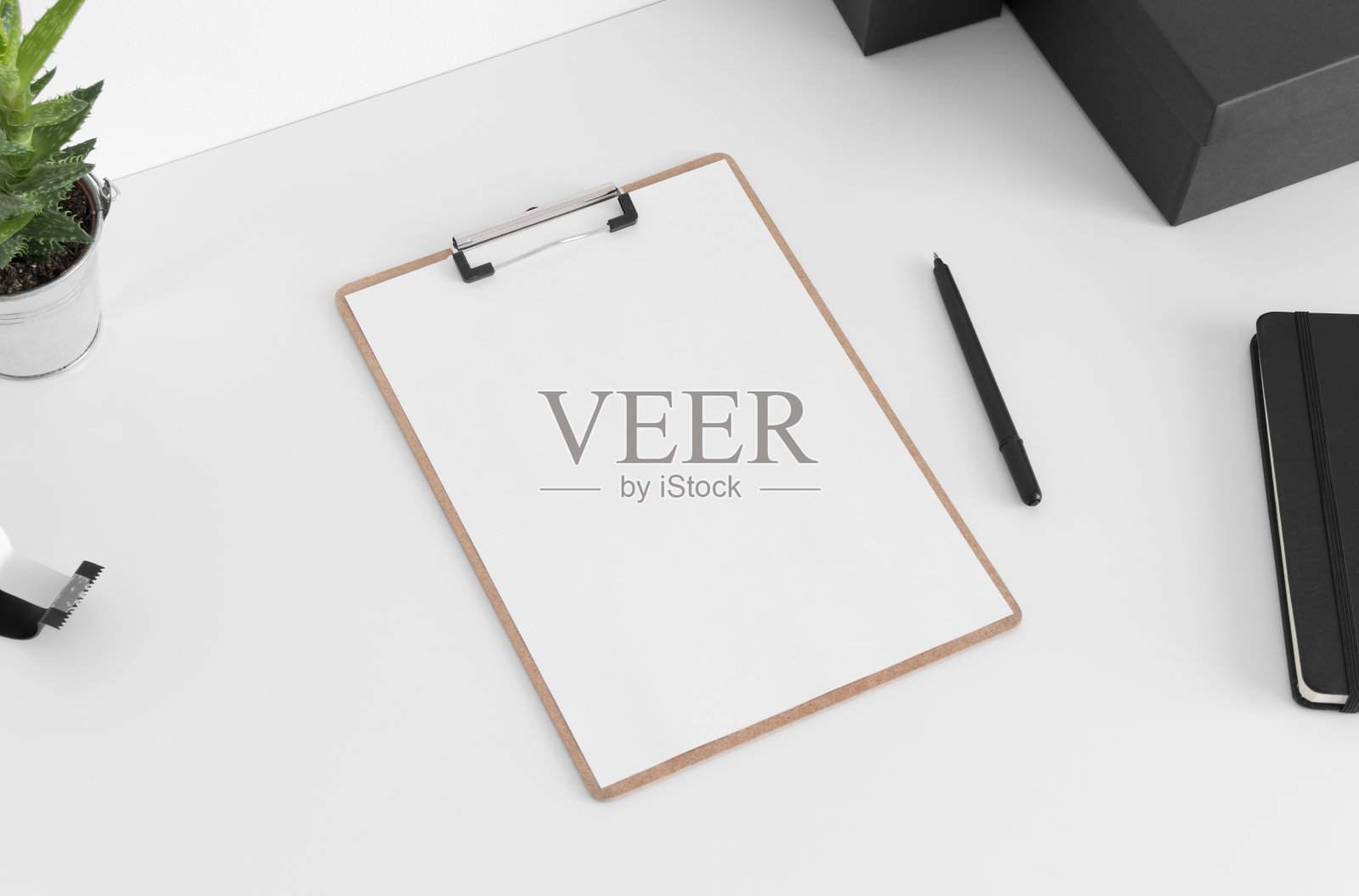 木制剪贴板模型与工作配件在白色桌子上。照片摄影图片