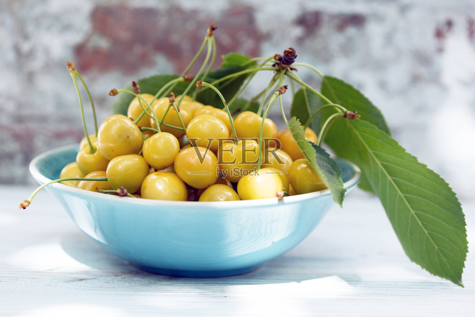 花园里桌子上的碗里盛着黄色樱桃照片摄影图片