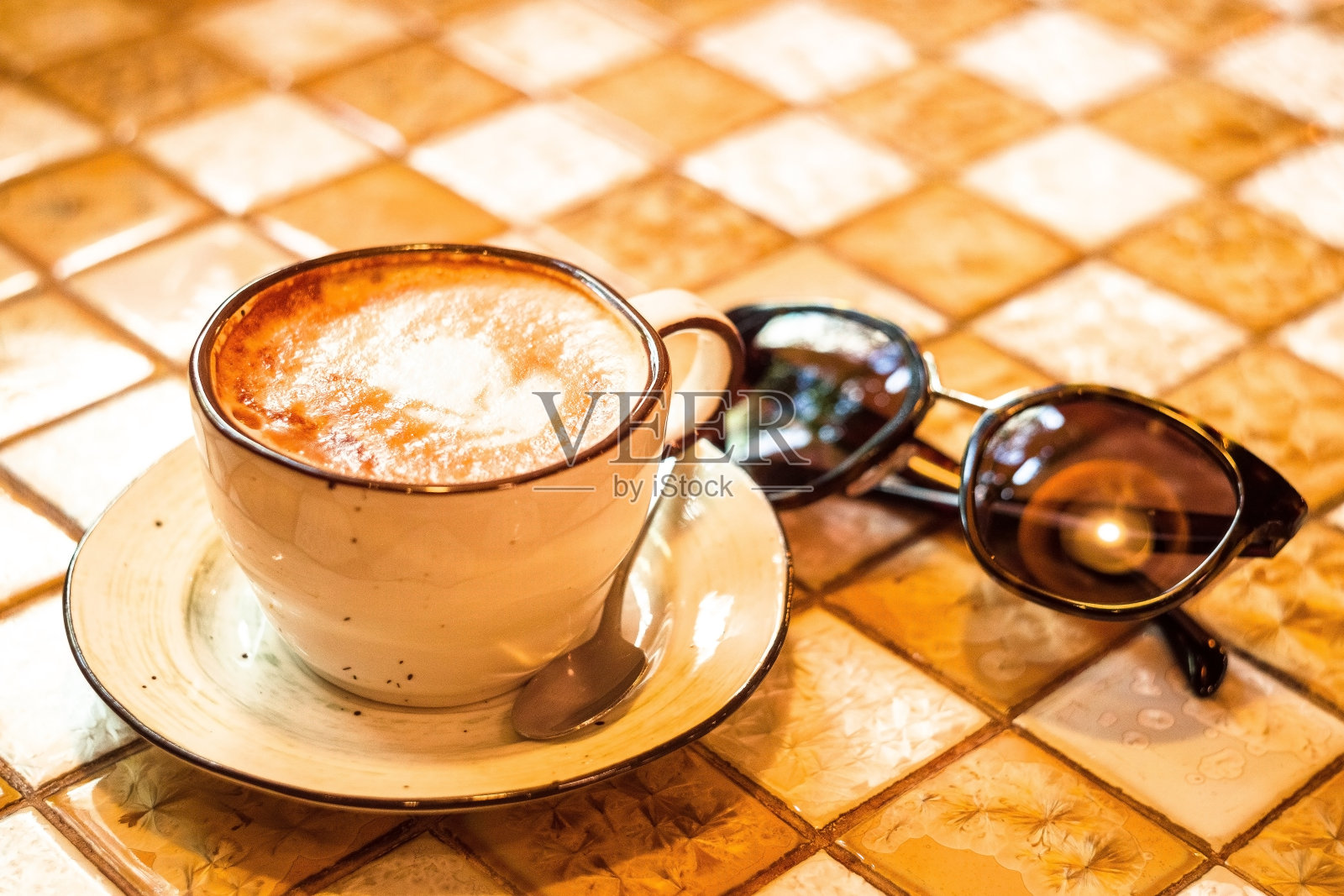 桌上的一杯卡布奇诺咖啡照片摄影图片