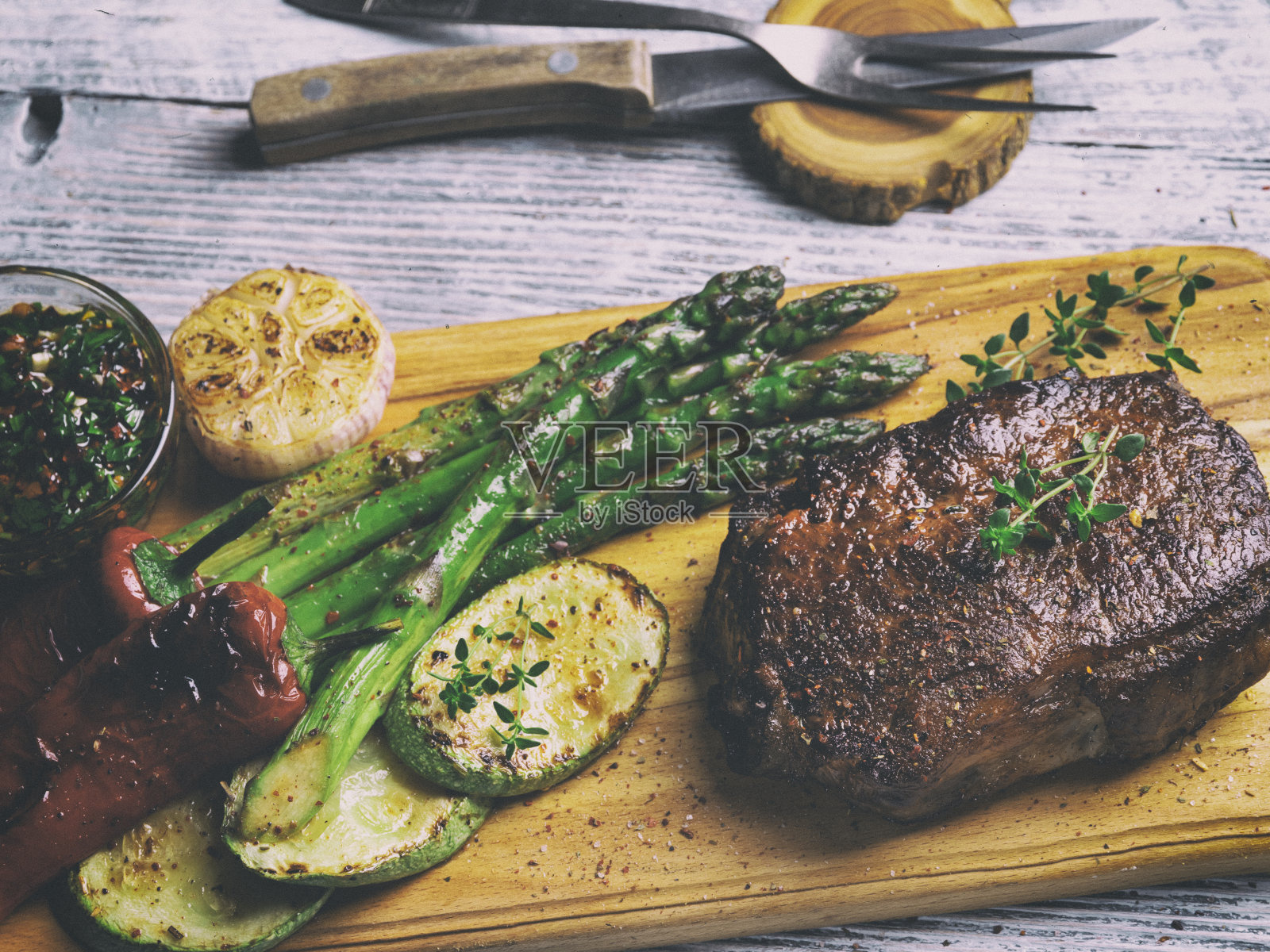 多汁的烤牛排配芦笋,胡椒,西葫芦,酱汁,近距离照片摄影图片