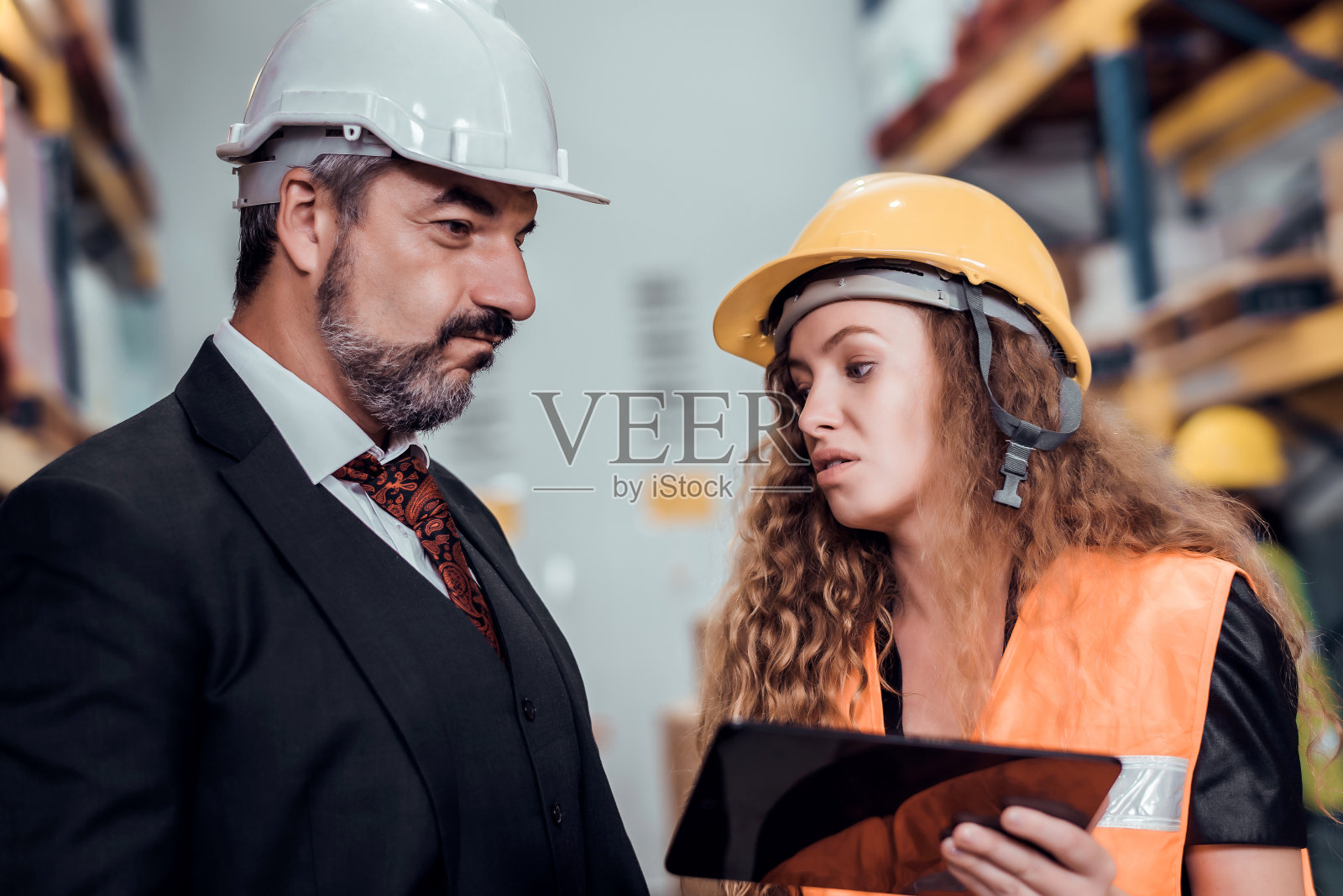 女工程师和商人戴着安全帽站在货物仓库,检查从货轮进口和出口的控制装载。团队合作理念照片摄影图片