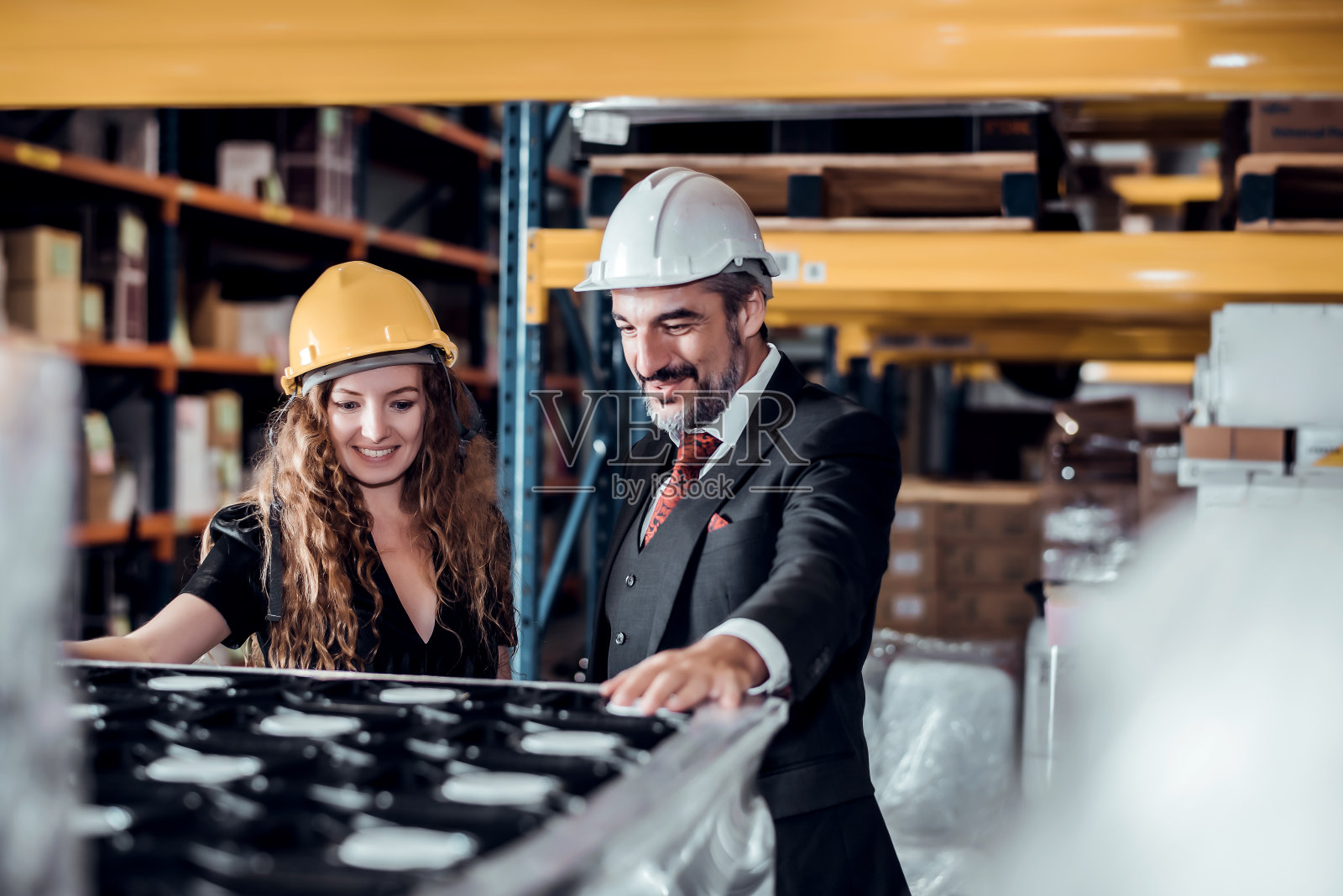 女工程师和商人戴着安全帽站在货物仓库,检查进出货轮的货物装载控制。团队合作理念照片摄影图片