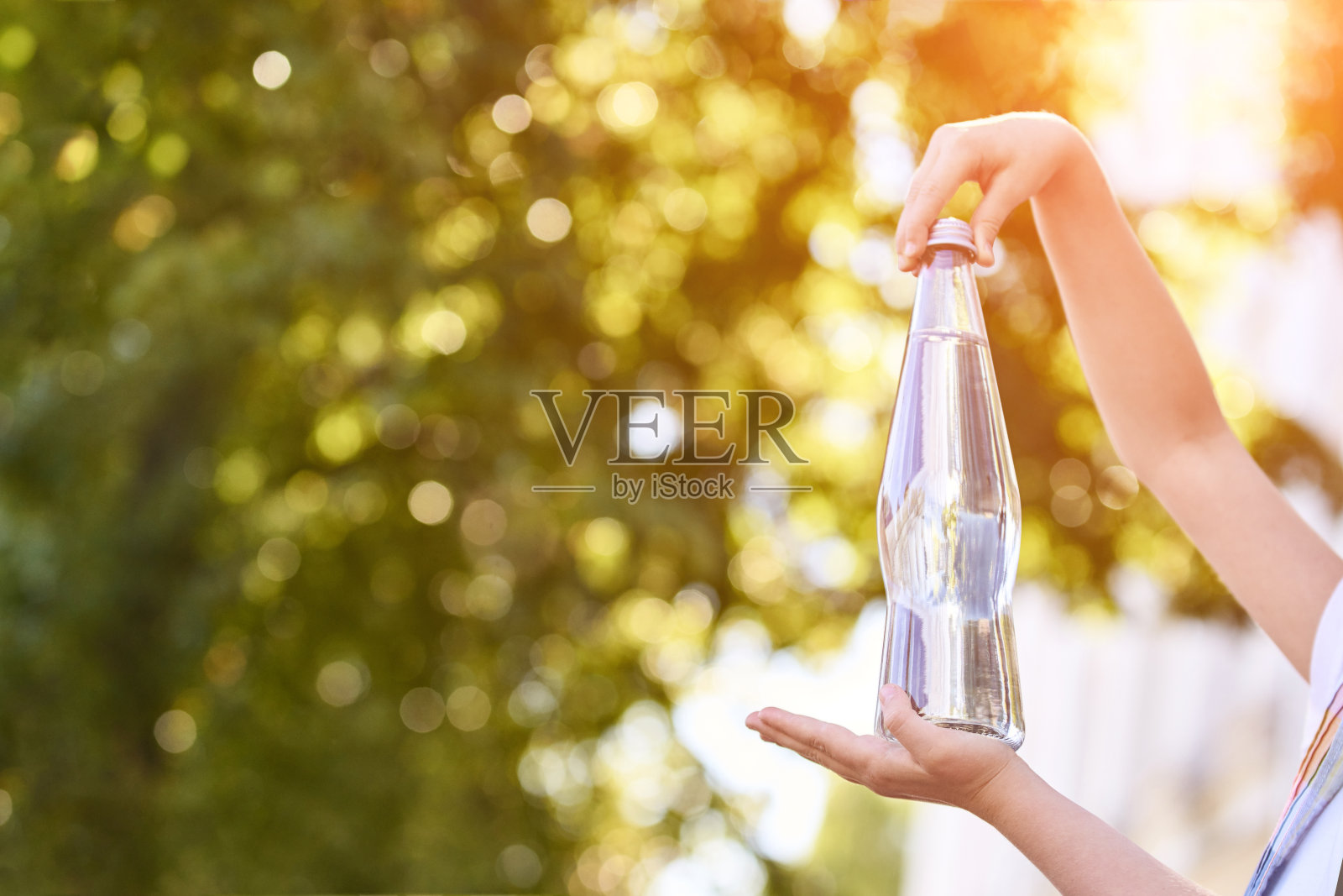 小女孩拿着水瓶。室外训练。渴了。玻璃喝照片摄影图片