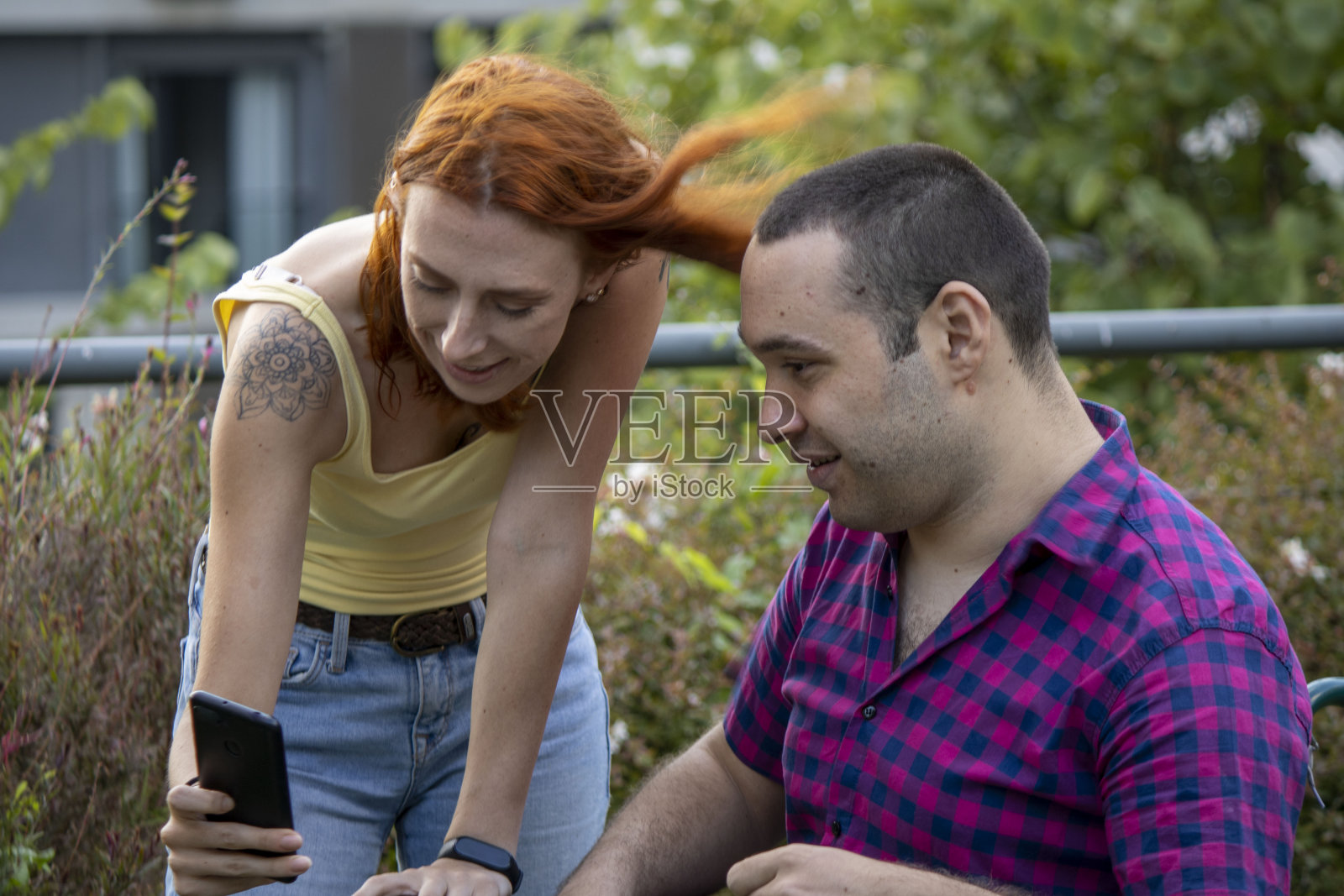 和坐在轮椅上的红头发女孩聊天照片摄影图片