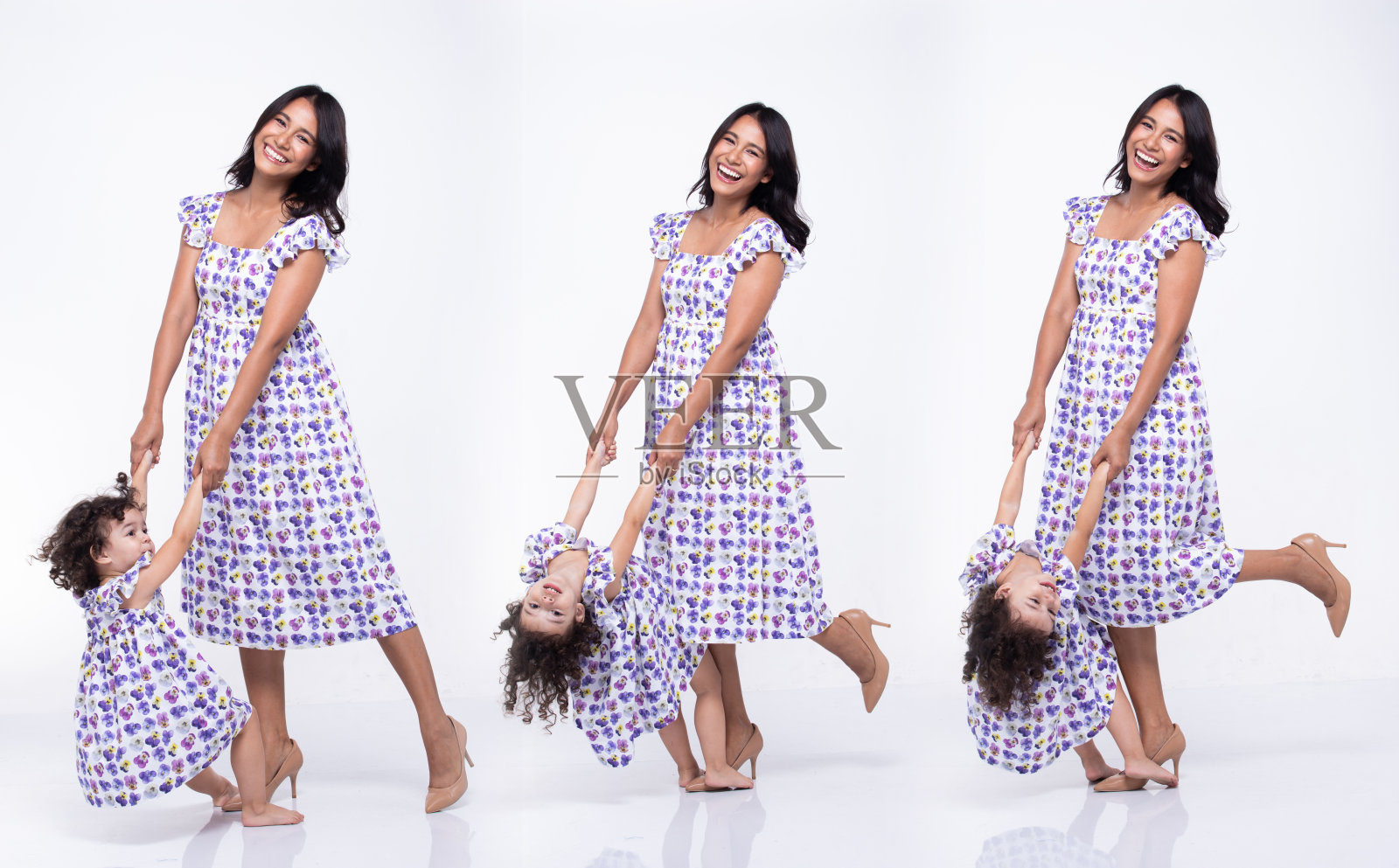 亚裔妈妈白人女儿小女孩牵着妈妈的手,用爱微笑照片摄影图片