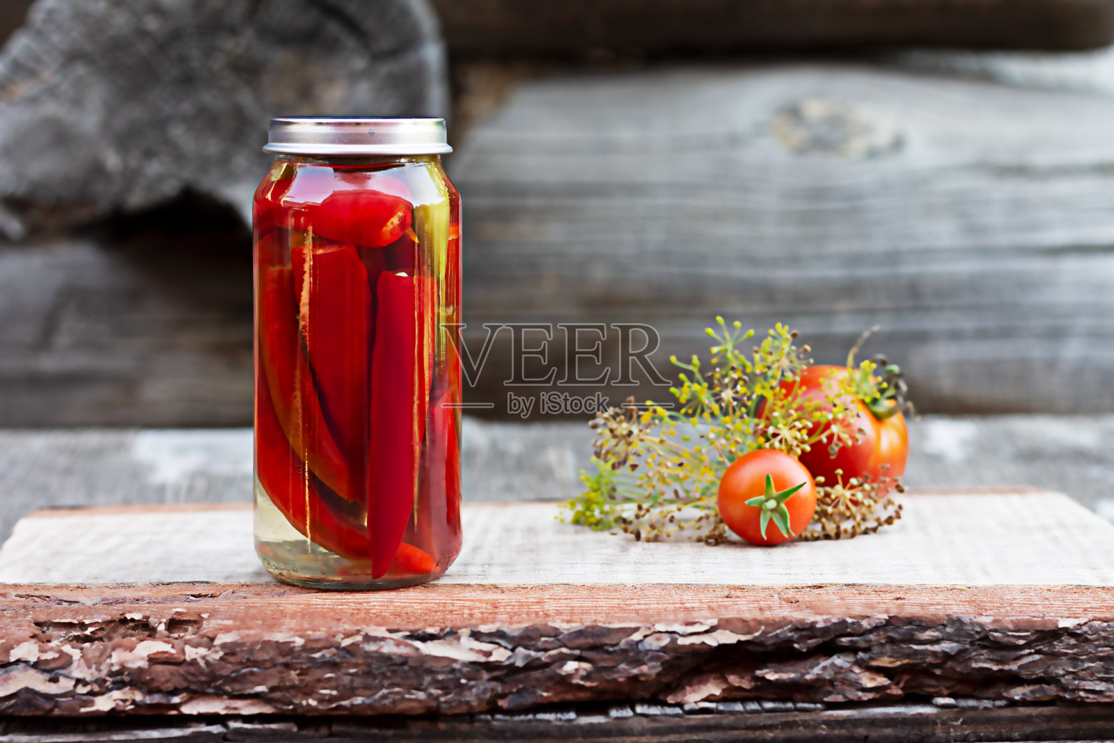 木桌上的玻璃罐里装着辣椒,自制泡菜照片摄影图片