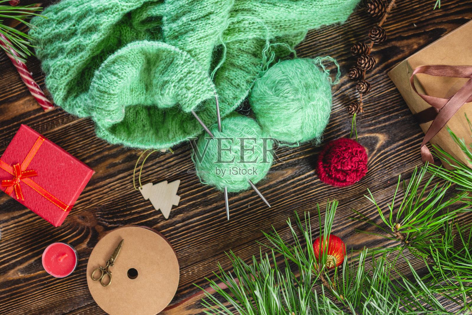 温暖舒适的毛衣在编织的过程中在针上。创造新年和圣诞节手工礼物的概念照片摄影图片