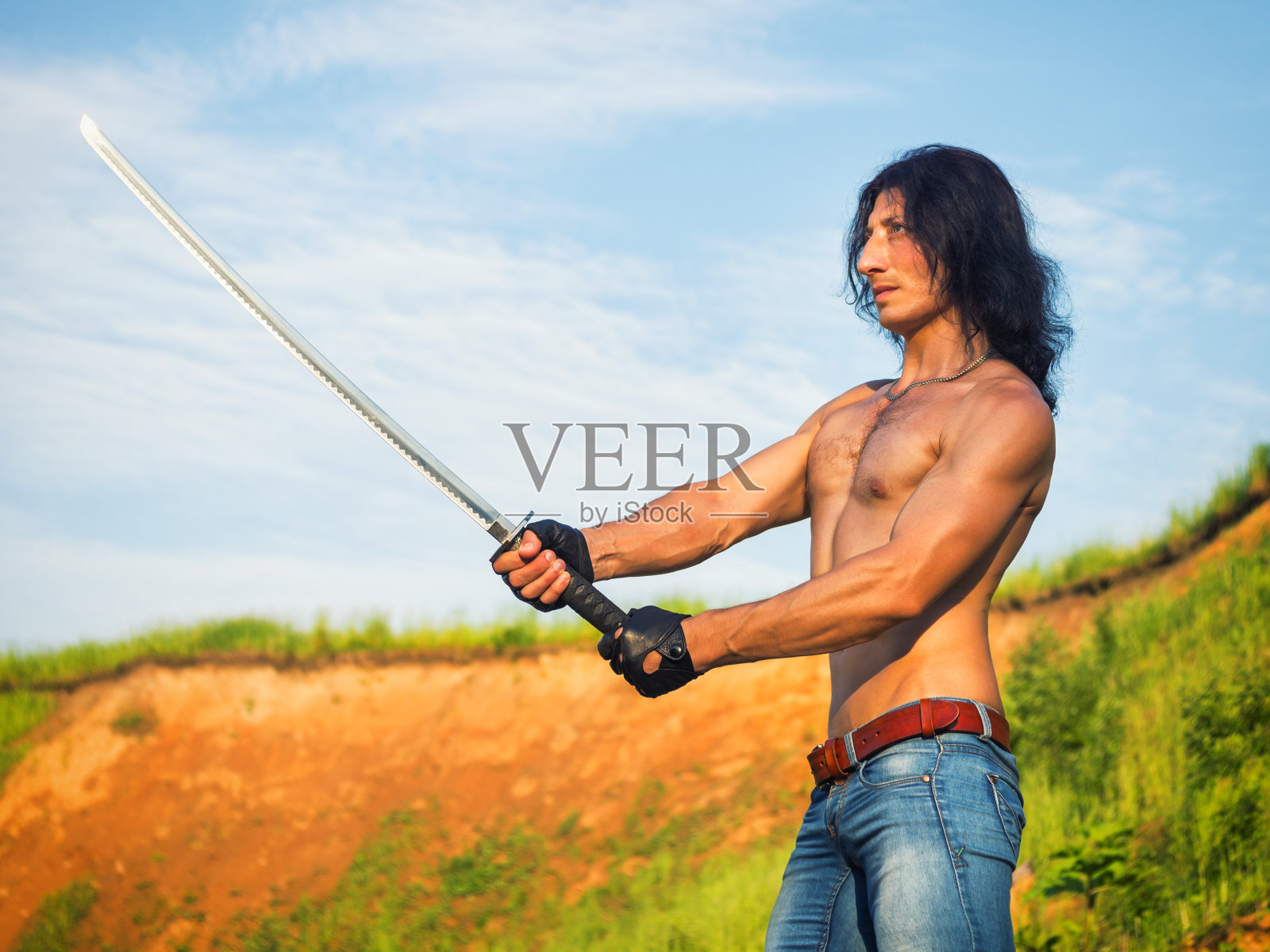 一个穿着牛仔裤的男人在夏天的户外。照片摄影图片