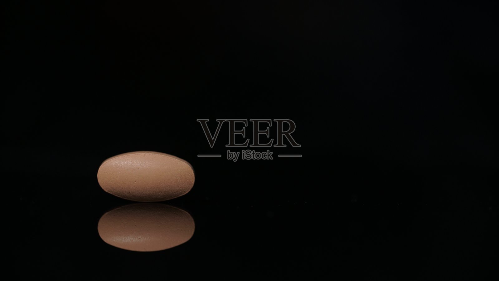 椭圆形的平板,孤立在黑色背景与反射。医学的概念照片摄影图片