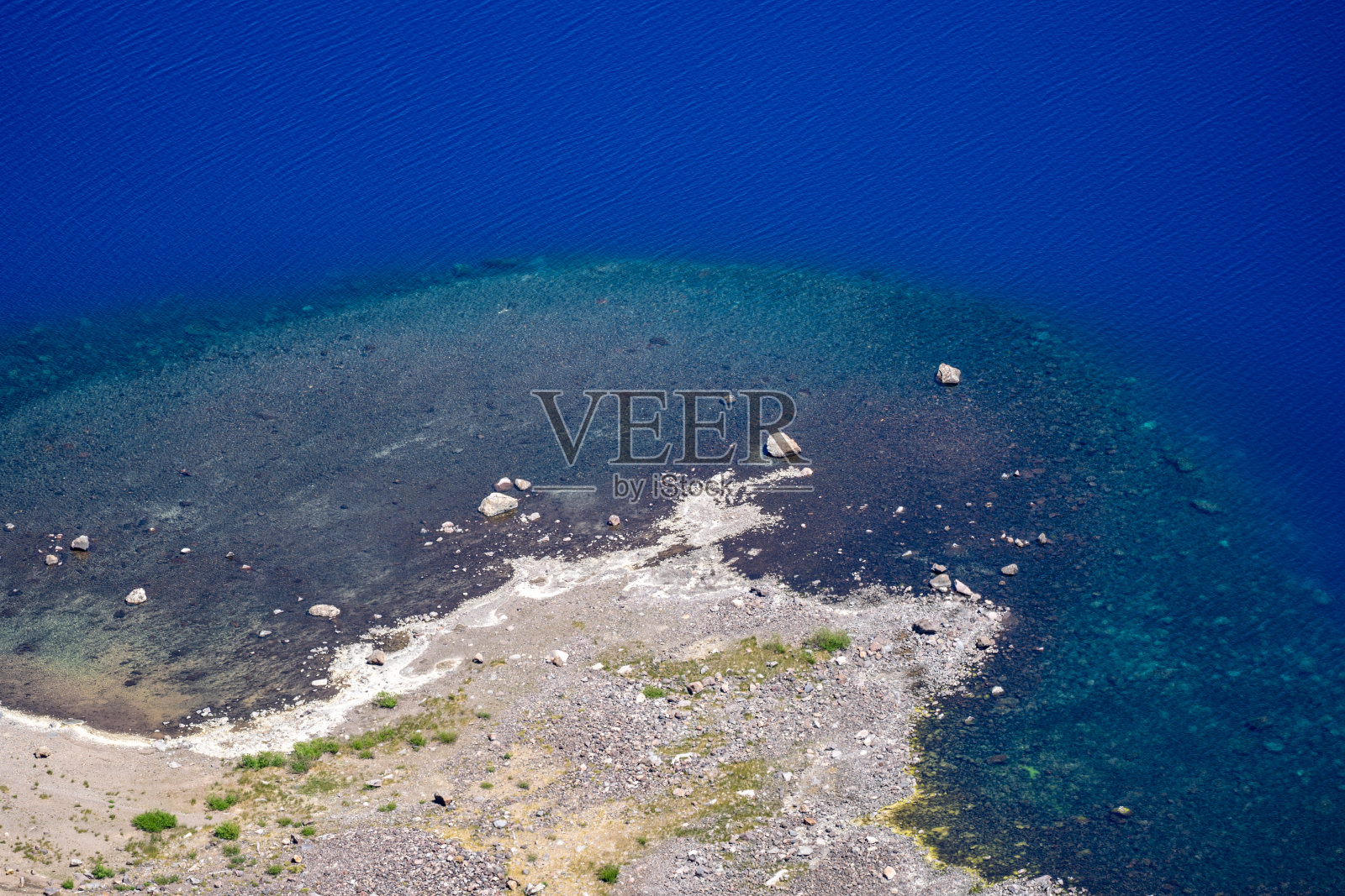 火山口湖国家公园的海岸线,有明亮的蓝色的水和白色的岩石照片摄影图片