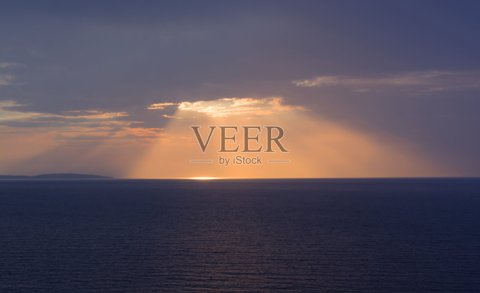 日落时,太阳穿过云层照耀着。美丽的景观照片摄影图片