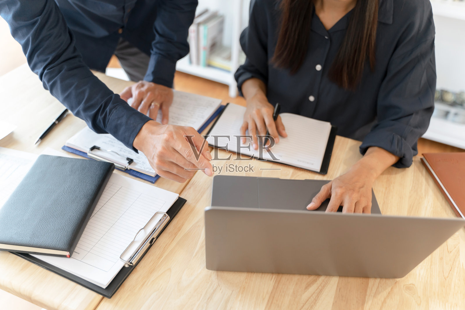 两名会计与财务图表的数据文件一起工作。照片摄影图片