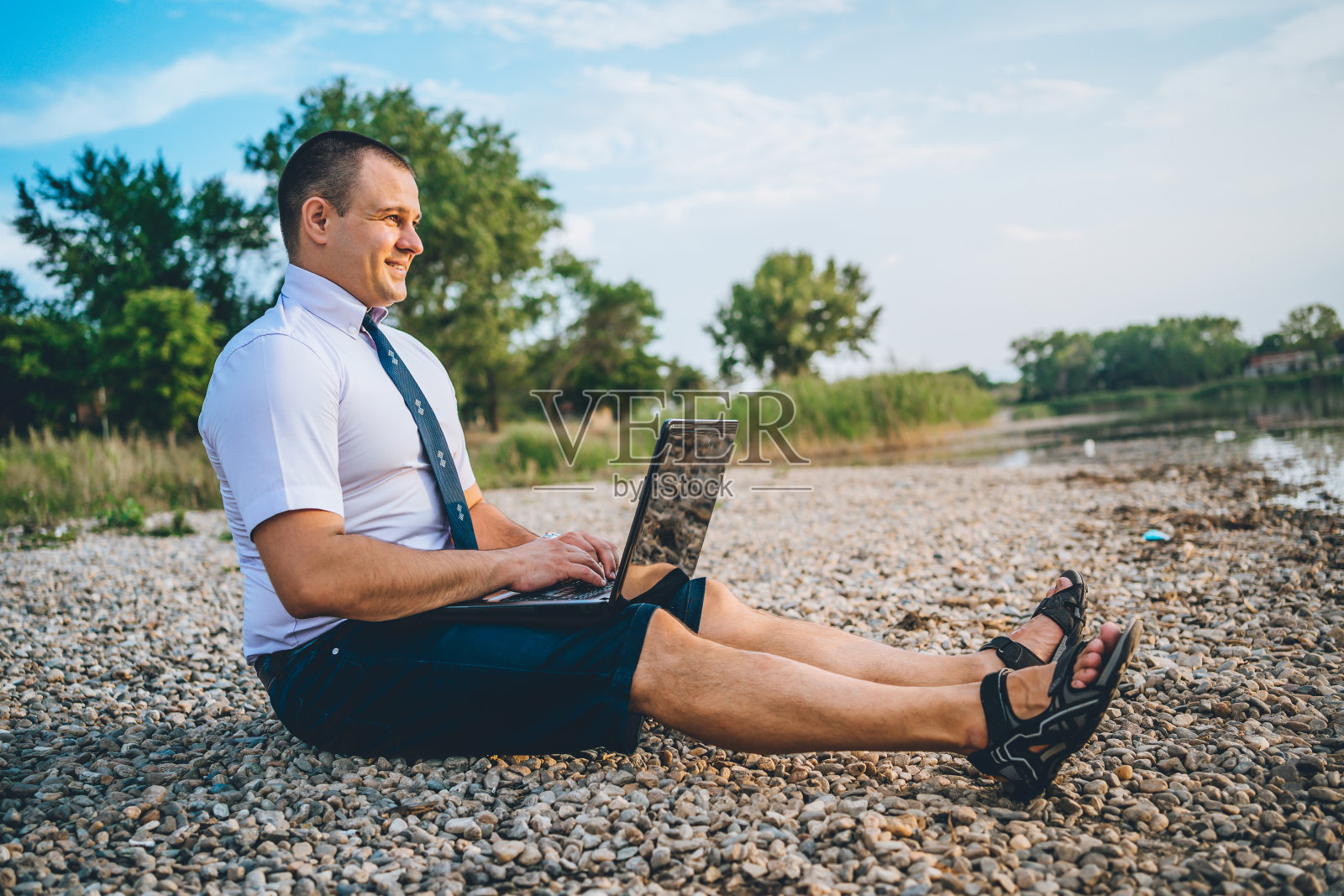 一个年轻人在湖边工作照片摄影图片