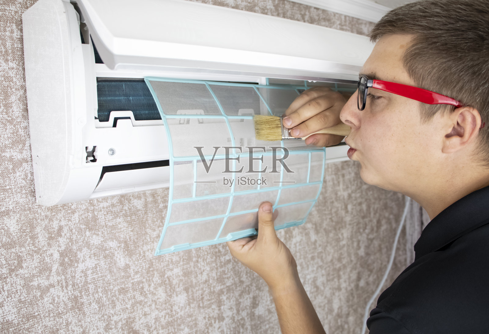 清除空调上的灰尘、霉菌和污垢。空调维修人员评估污染水平,清洁散热器,并从空洞冲洗出污染。照片摄影图片