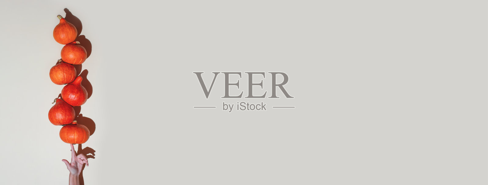 一只手平衡橙色南瓜。万圣节主题的概念照片摄影图片