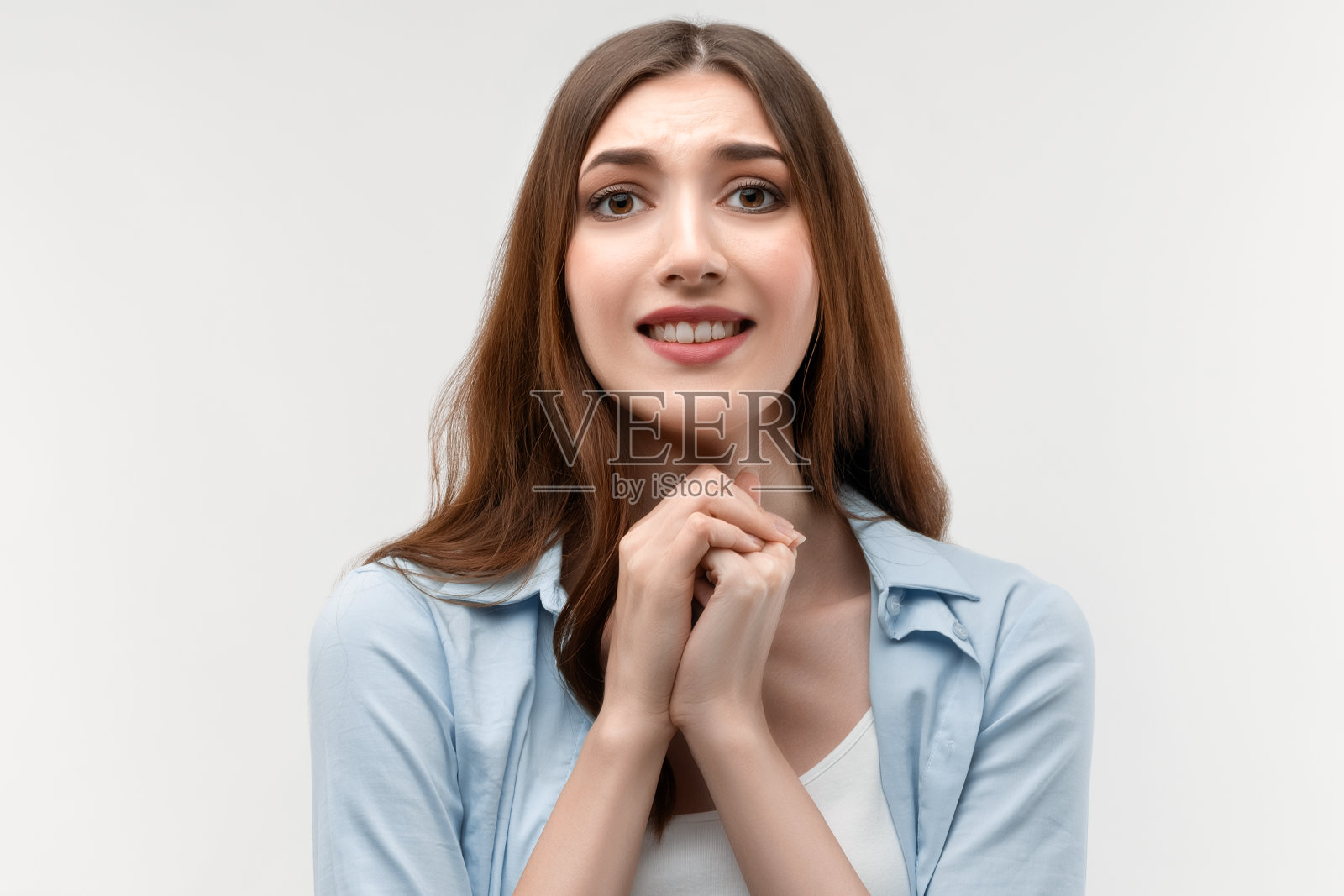 照片魅力深褐色的女性与长直发,保持在一起的手靠近下巴照片摄影图片