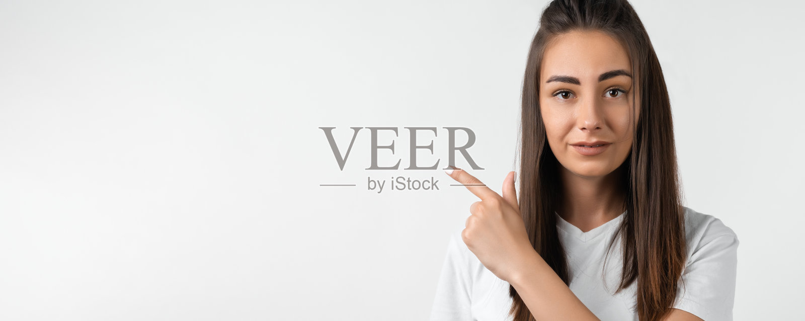 栗色长发的女孩,用一根手指指着你,为你的晋升显示空白照片摄影图片