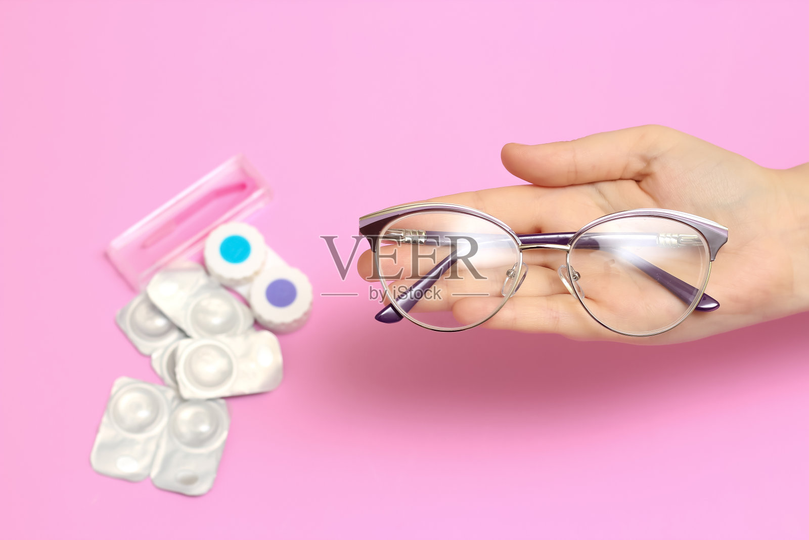 粉色背景的眼镜和隐形眼镜。视力矫正。眼镜的景象。眼镜或隐形眼镜。照片摄影图片