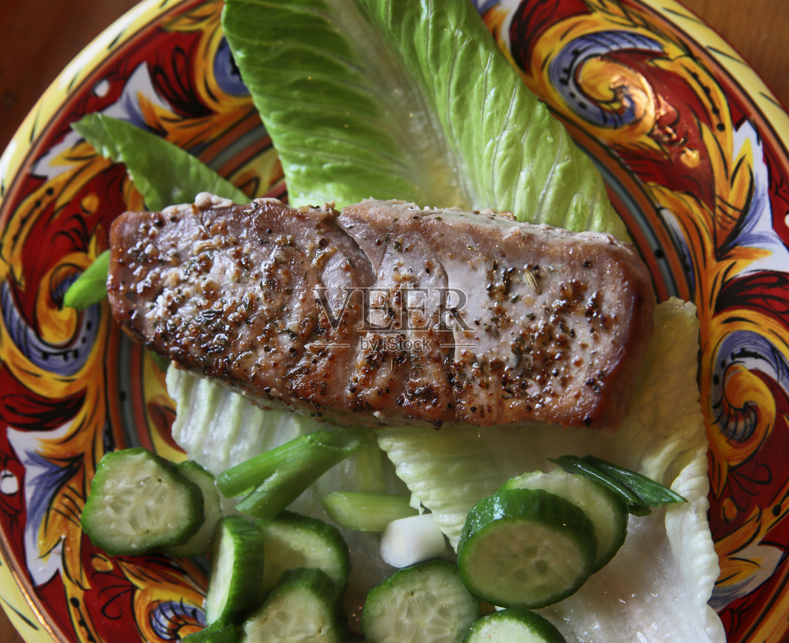 沙拉叶子上放了一片金枪鱼。照片摄影图片