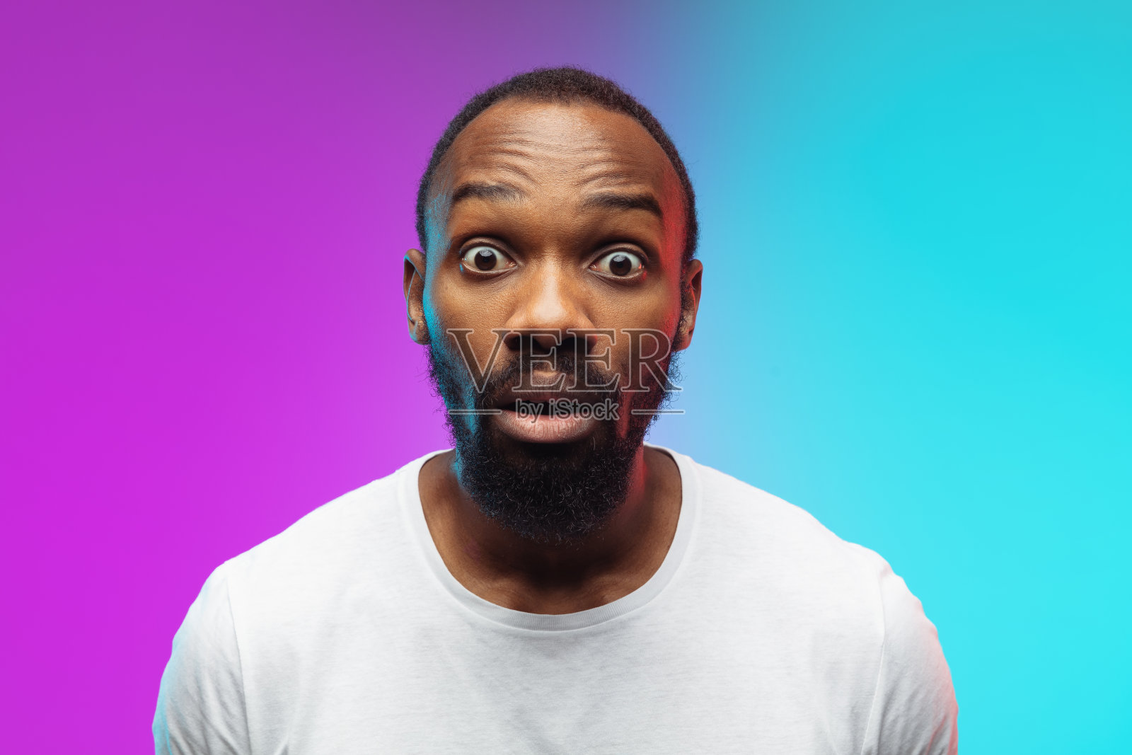 非裔美国年轻人的肖像在渐变工作室背景霓虹灯,特写照片摄影图片