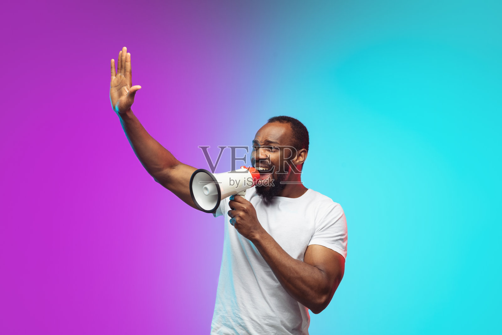 非裔美国年轻人的肖像在渐变工作室背景霓虹灯照片摄影图片