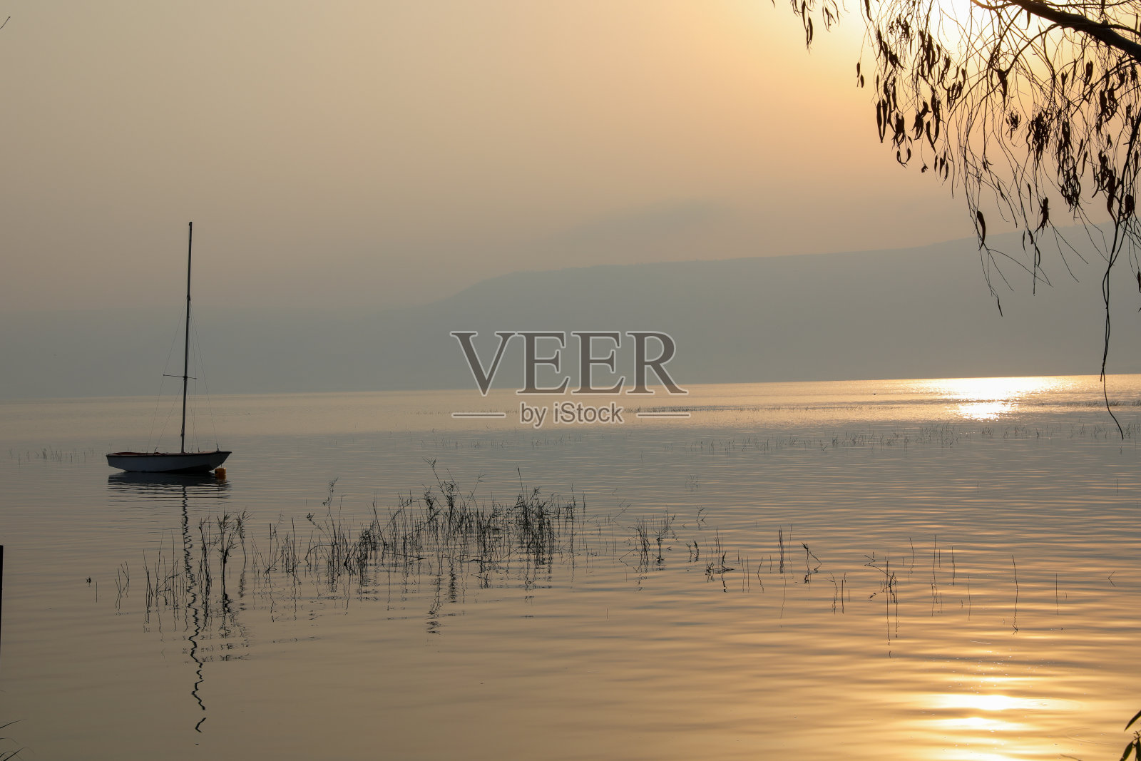 湖面日出:平静水面上漂浮的船只照片摄影图片