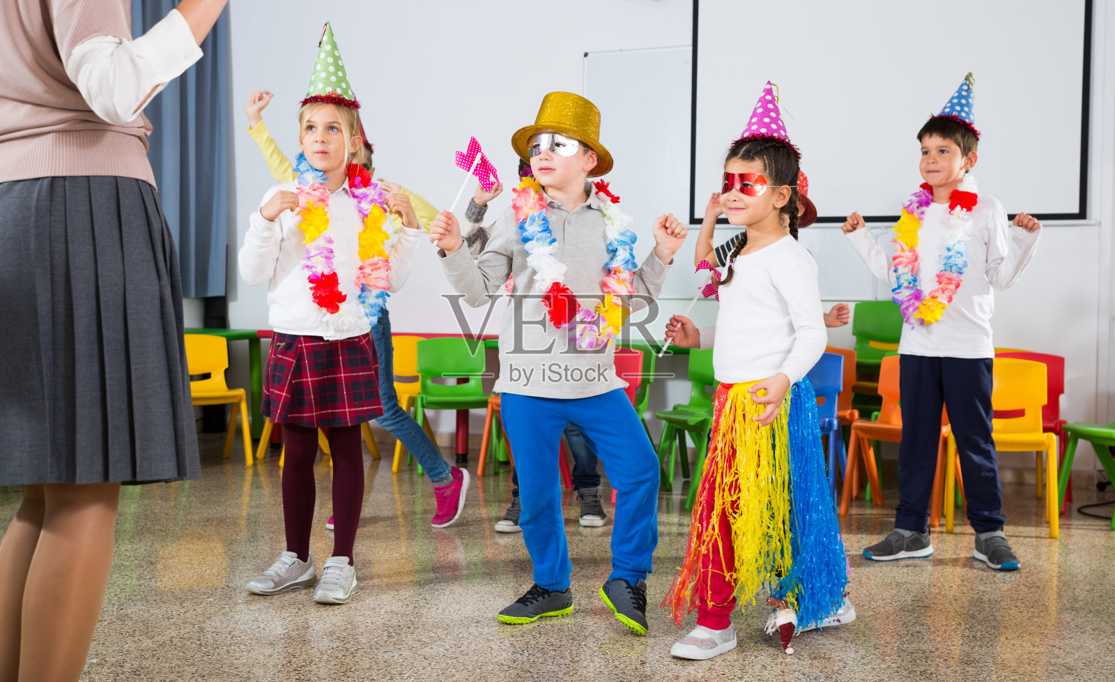 孩子们和老师戴着滑稽的帽子跳舞照片摄影图片