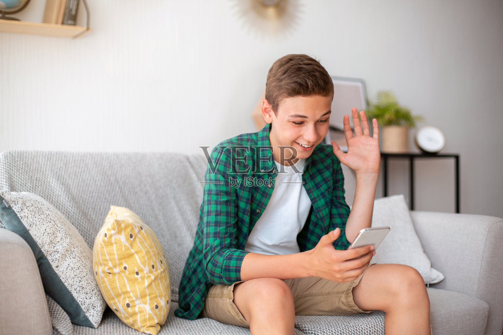 积极的青少年有视频通话,在家里用电话照片摄影图片