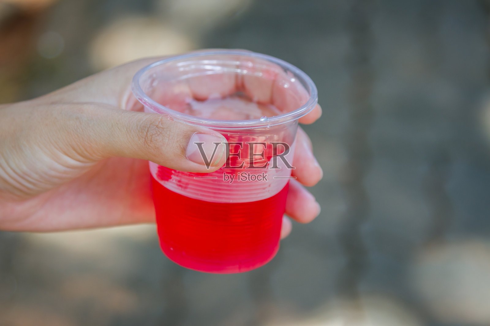女手捧着水杯喝着红色的液体照片摄影图片