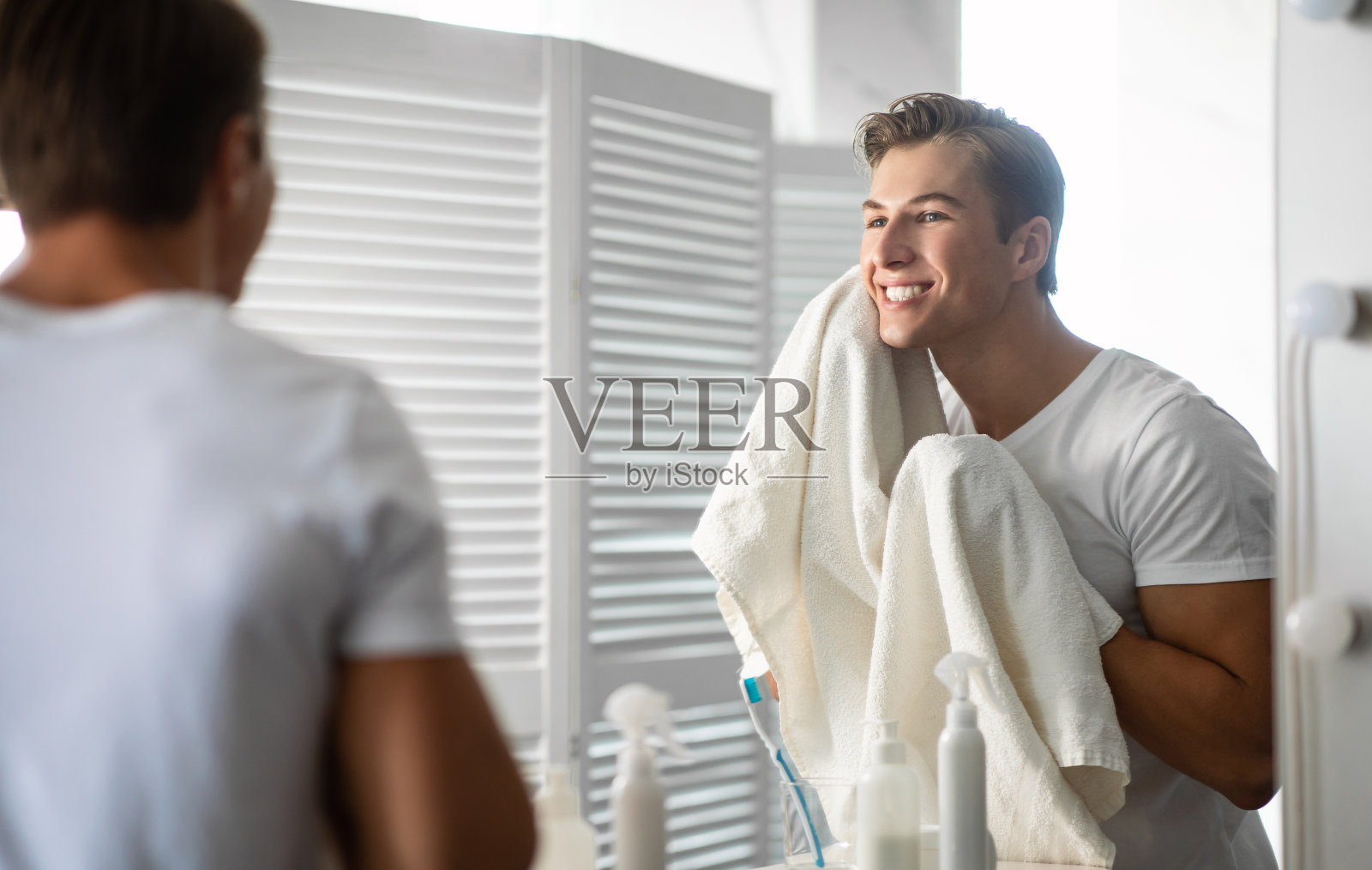 自信的年轻人用毛巾照镜子照片摄影图片