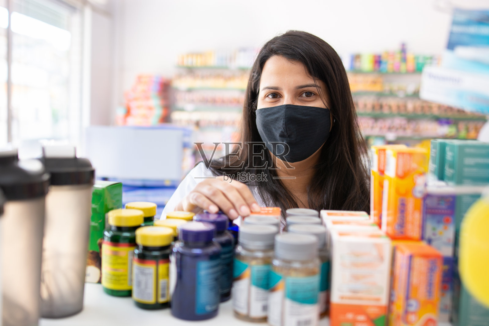 戴口罩在药房工作的药剂师照片摄影图片