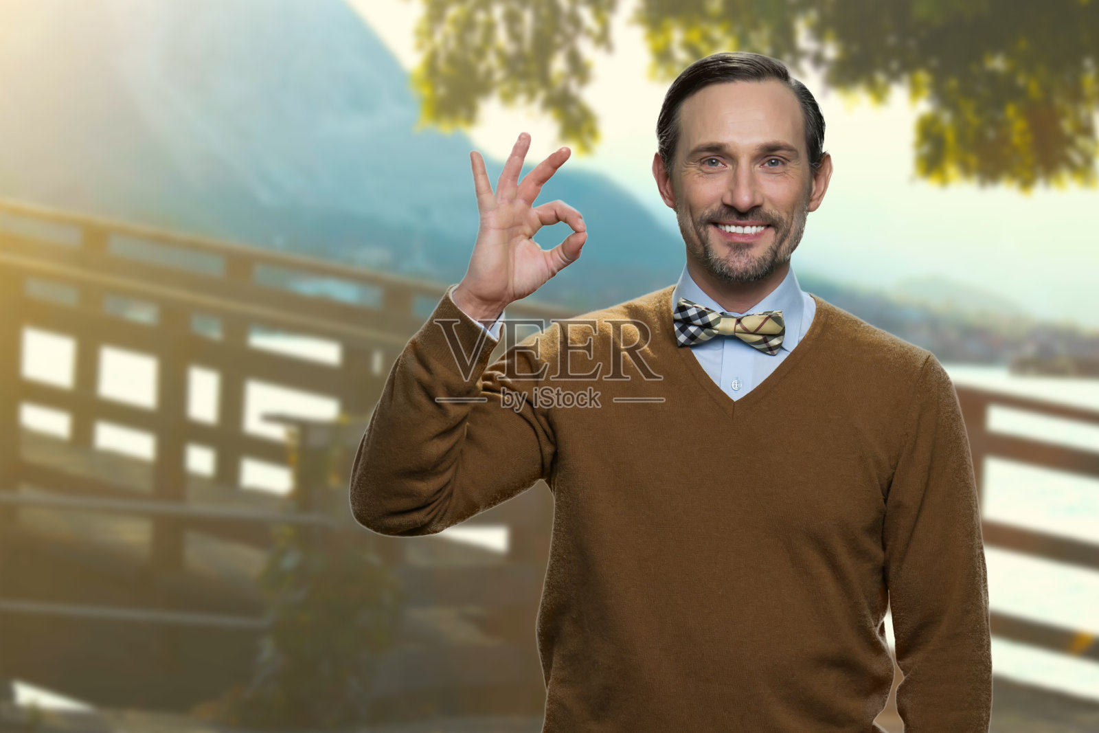 英俊成熟的男人在户外表现出良好的象征。照片摄影图片