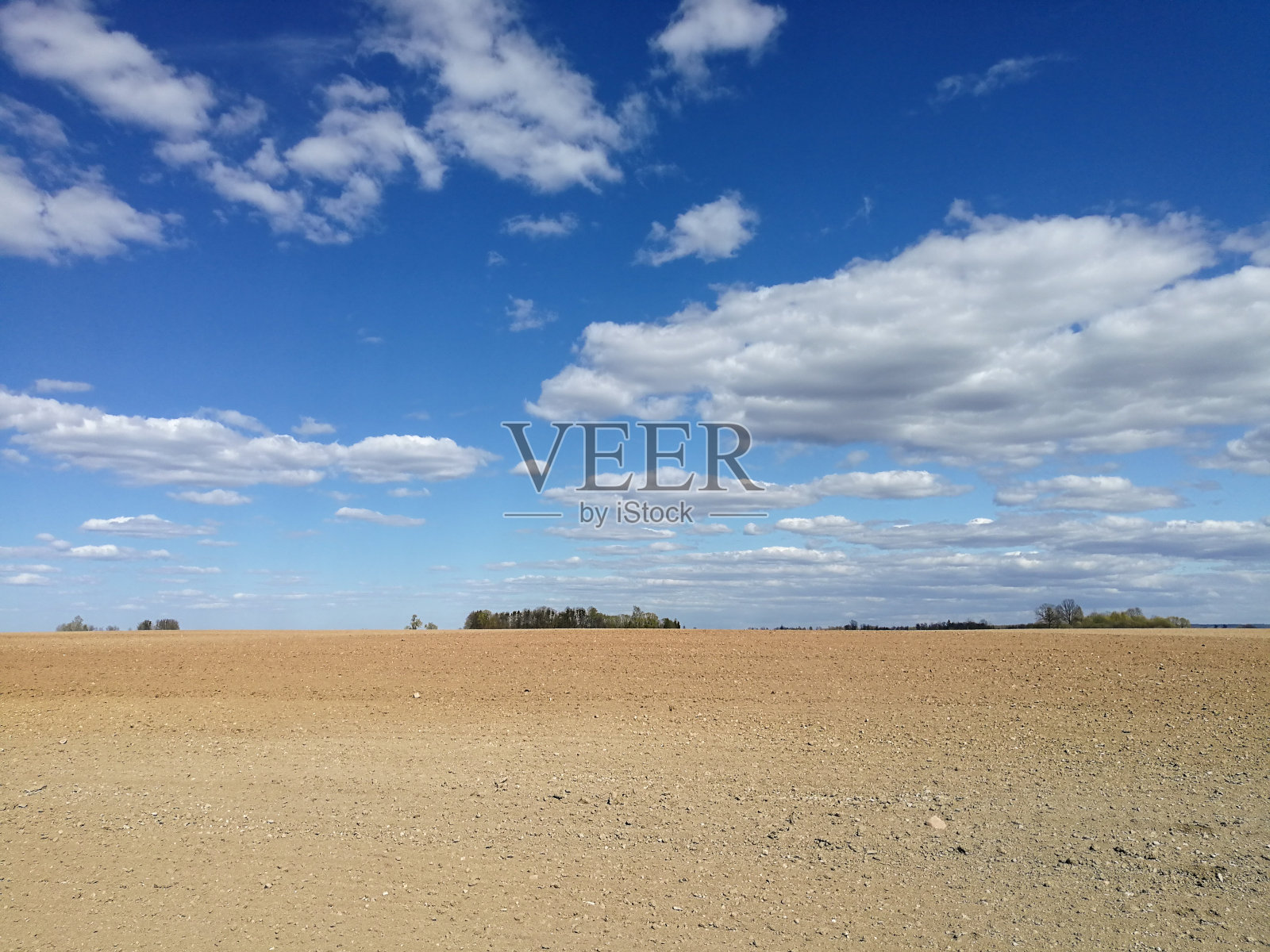 犁过的田地和多云的天空照片摄影图片