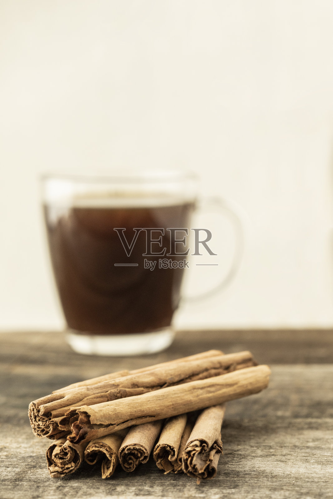 木桌上一堆肉桂,背景是咖啡照片摄影图片