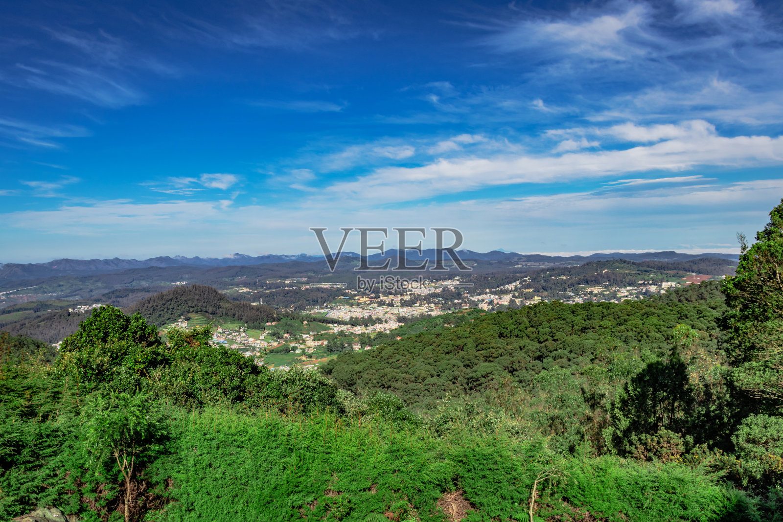 白天,从山顶俯瞰城市,可以看到连绵的山脉和湛蓝的天空照片摄影图片