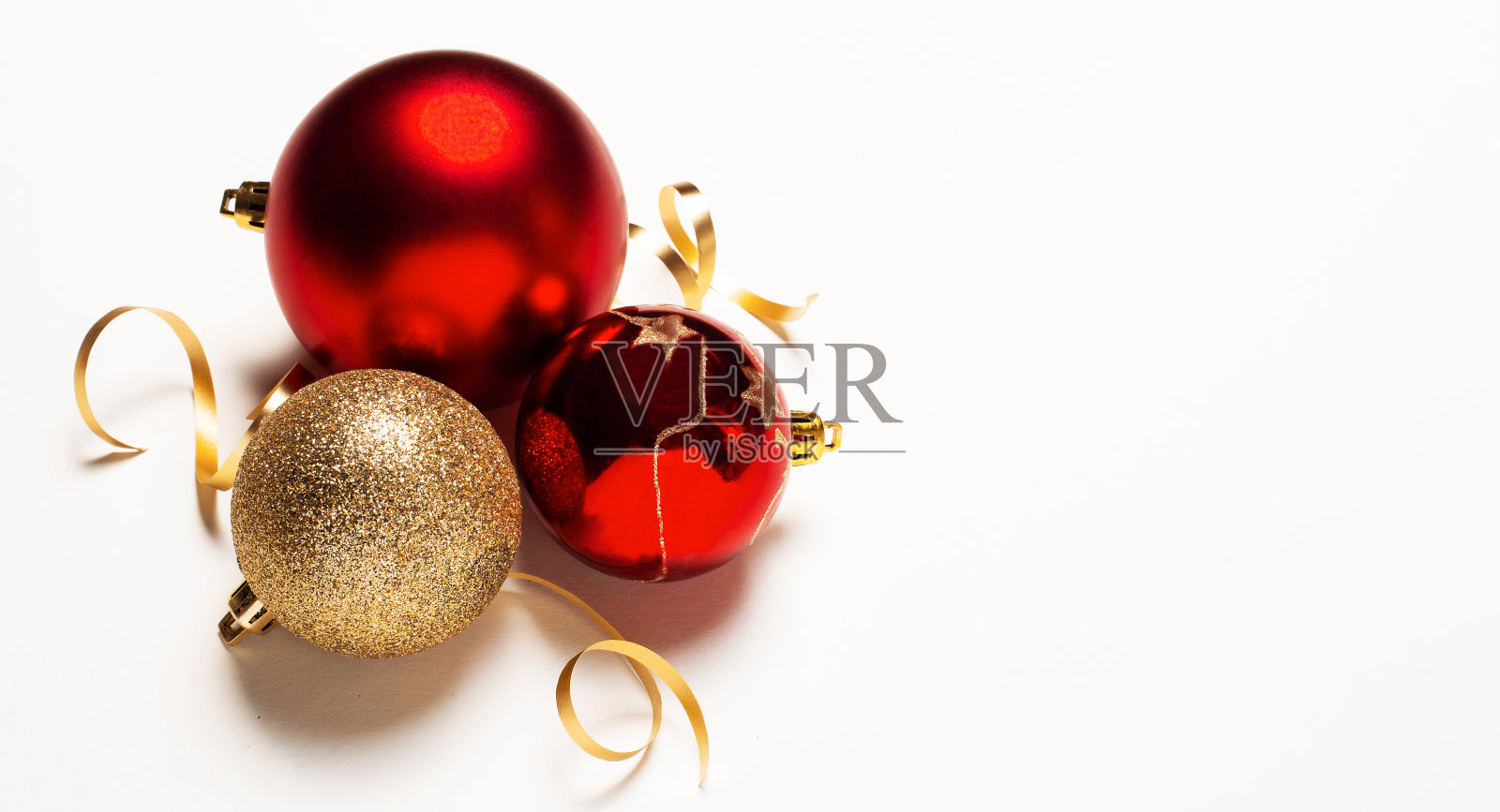 三个红色圣诞球的装饰,孤立在白色背景与裁剪路径。红色和金色的球在白色的背景。圣诞装饰。圣诞装饰品特写。圣诞节的概念照片摄影图片