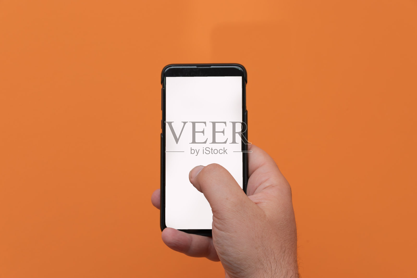 男子使用移动智能手机孤立在橙色背景。照片摄影图片