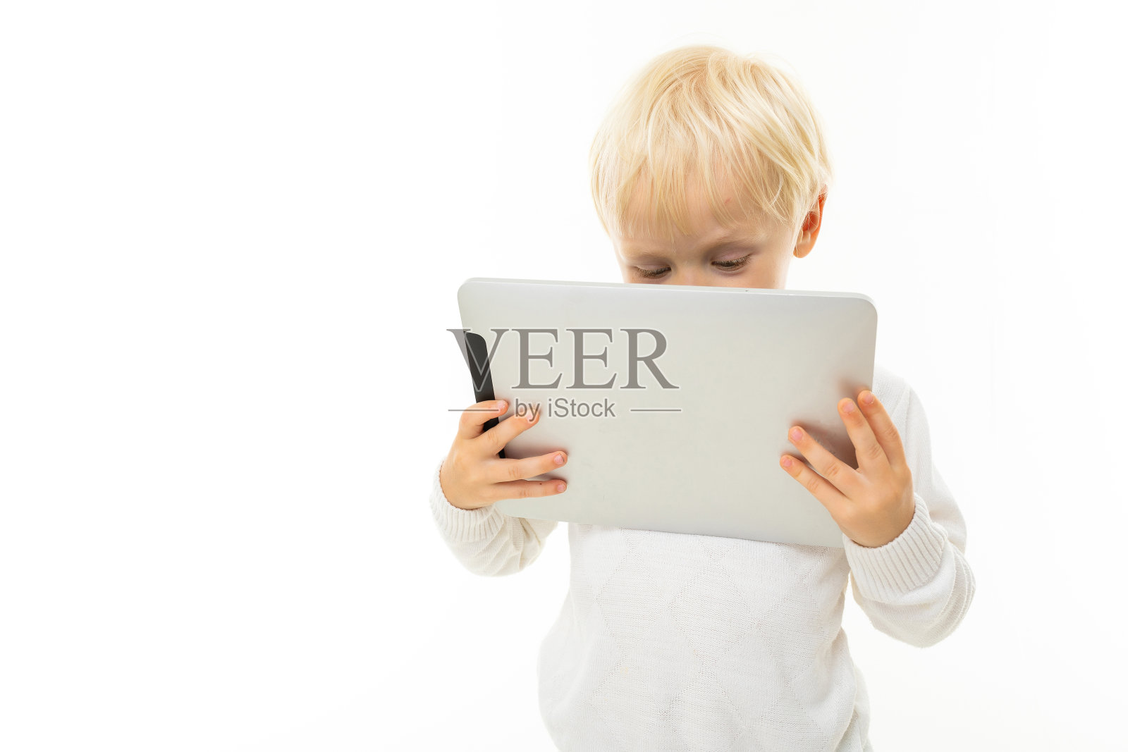 金发白种人小男孩看平板孤立在白色的背景照片摄影图片