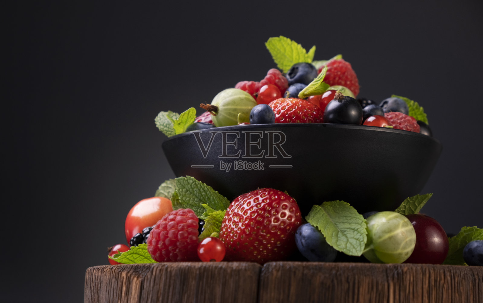 混合的野生浆果在黑色的背景照片摄影图片