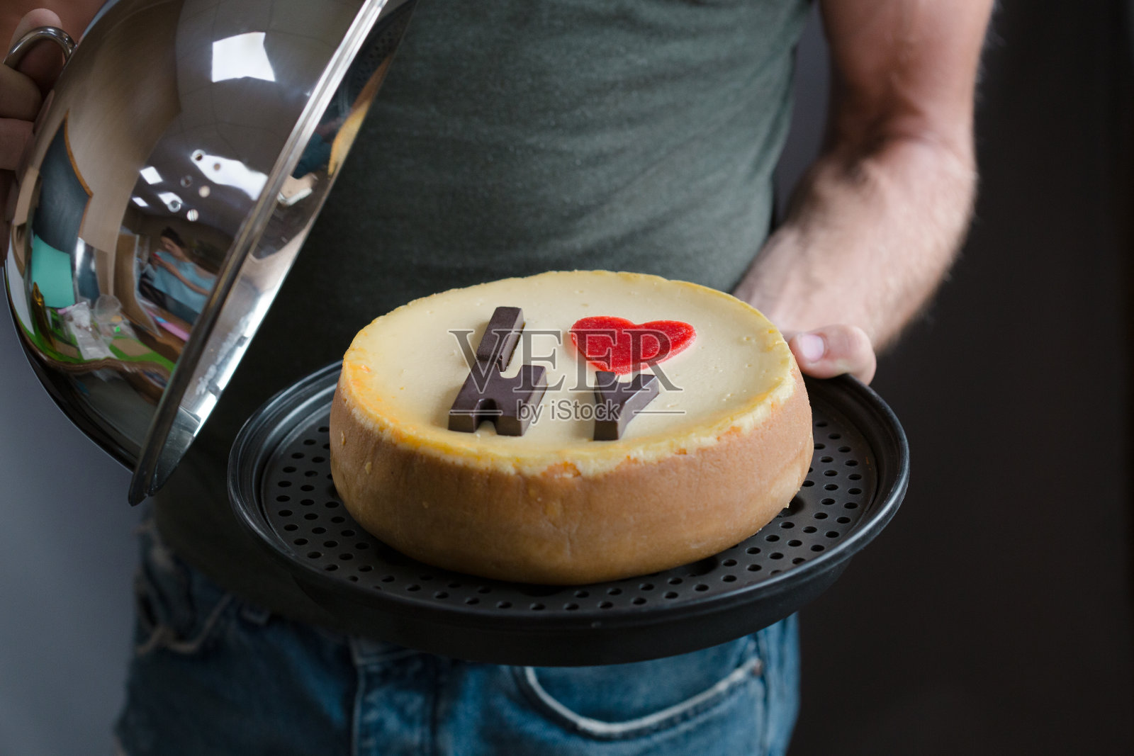 飞机圆的经典纽约芝士蛋糕在男人的手中。烘焙的概念和甜蛋糕甜点照片摄影图片