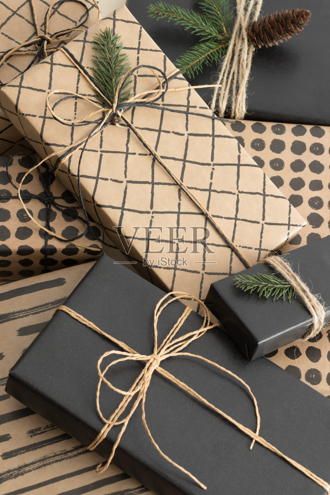 多色彩缤纷的圣诞礼物与松果和树叶。照片摄影图片