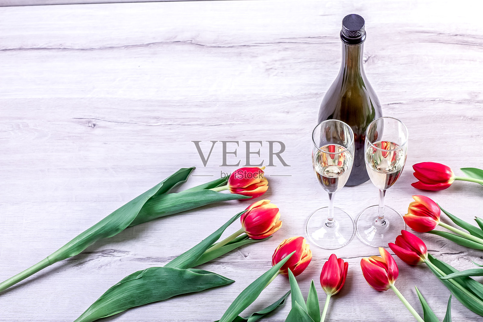 白色木桌上放着一束彩色郁金香。妇女节和3月8日的鲜花。照片摄影图片